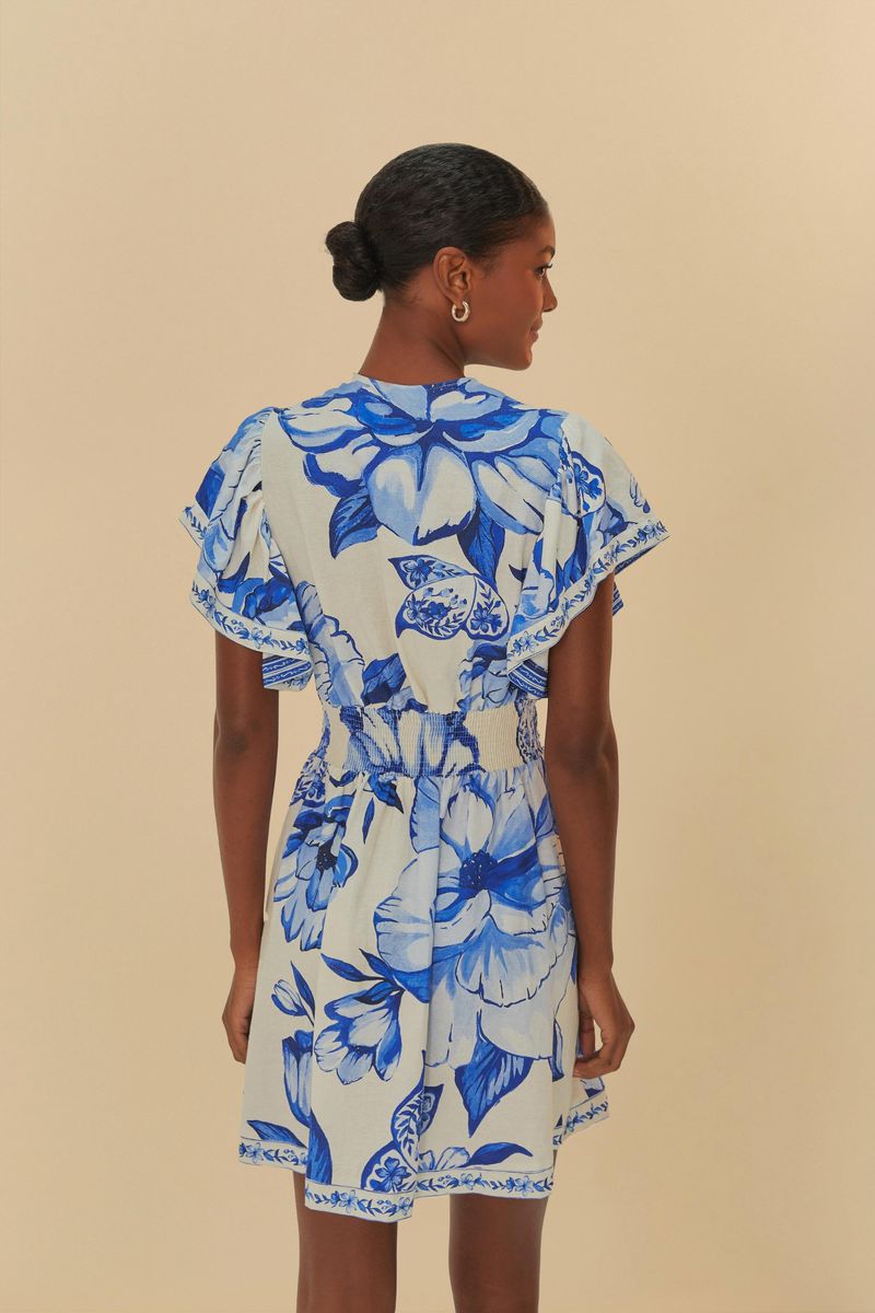 Vista-trasera-del-vestido-corto-con-estampado-floral-azul-mostrando-el-corte-y-las-mangas-cortas.