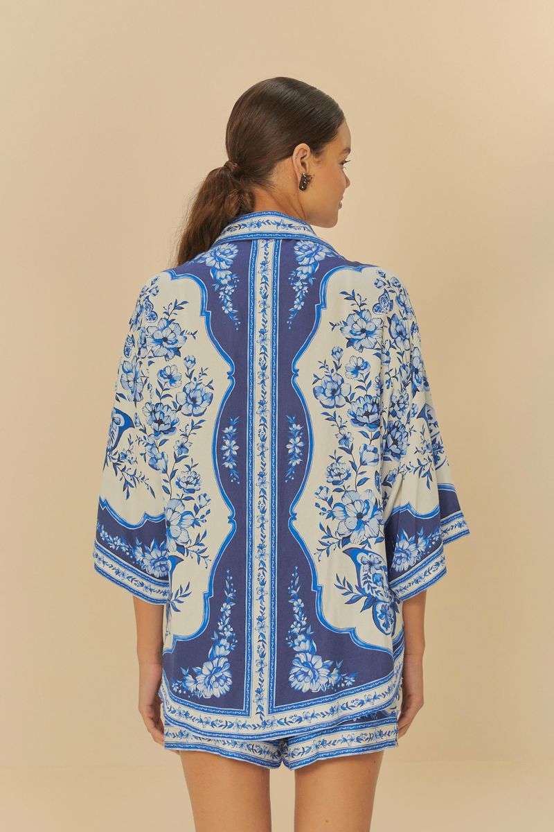 Vista trasera de la camisa con estampado floral simétrico y ornamentos.