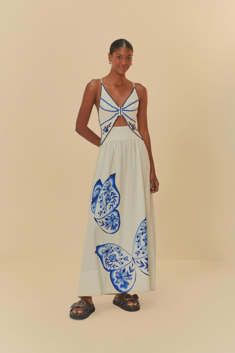 Vestido-largo-con-bordado-de-mariposa-azul-en-fondo-blanco-tirantes-finos-y-escote-profundo.