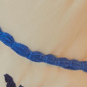 Detalle-del-bordado-azul-en-el-corse-del-vestido.