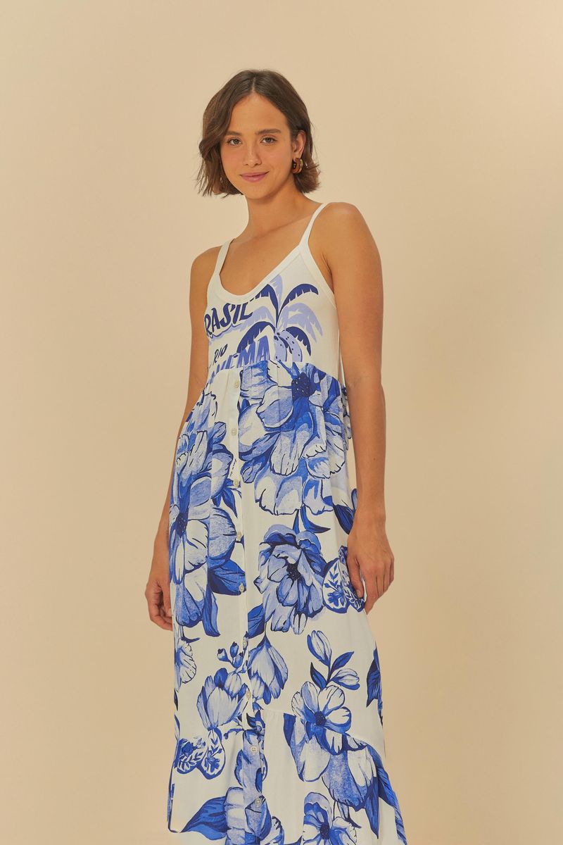 Modelo-usando-un-vestido-tipo-cropped-con-tiras-delgadas-estampado-floral-azul-con-fondo-blanco-vista-lateral.