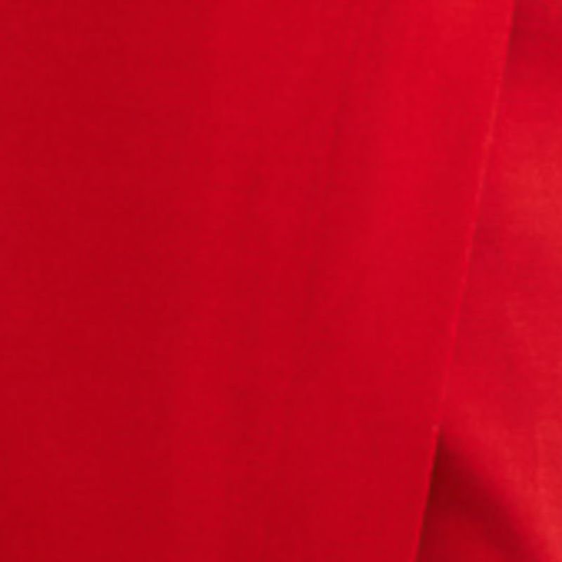 Detalle de la tela roja del vestido mostrando su textura.