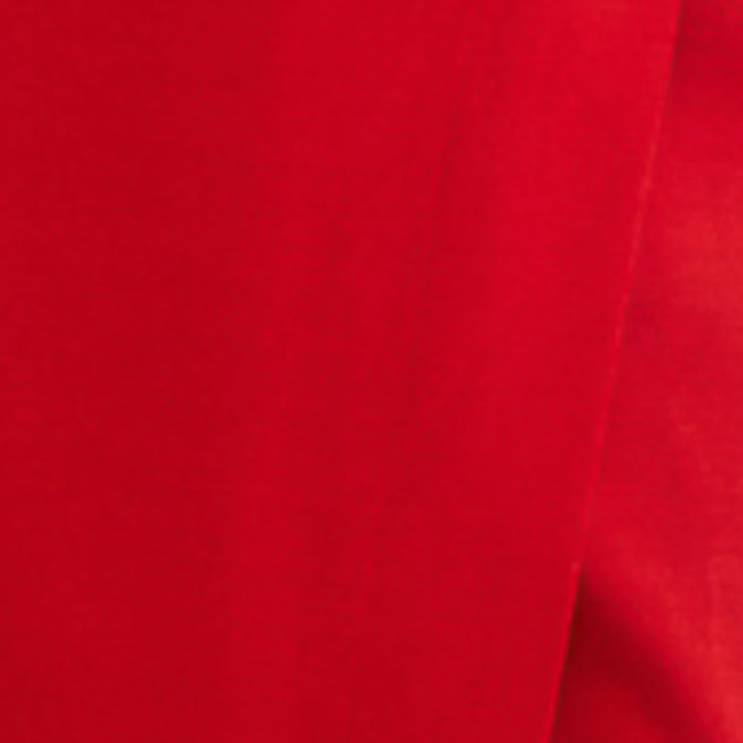 Detalle de la tela roja del vestido mostrando su textura.