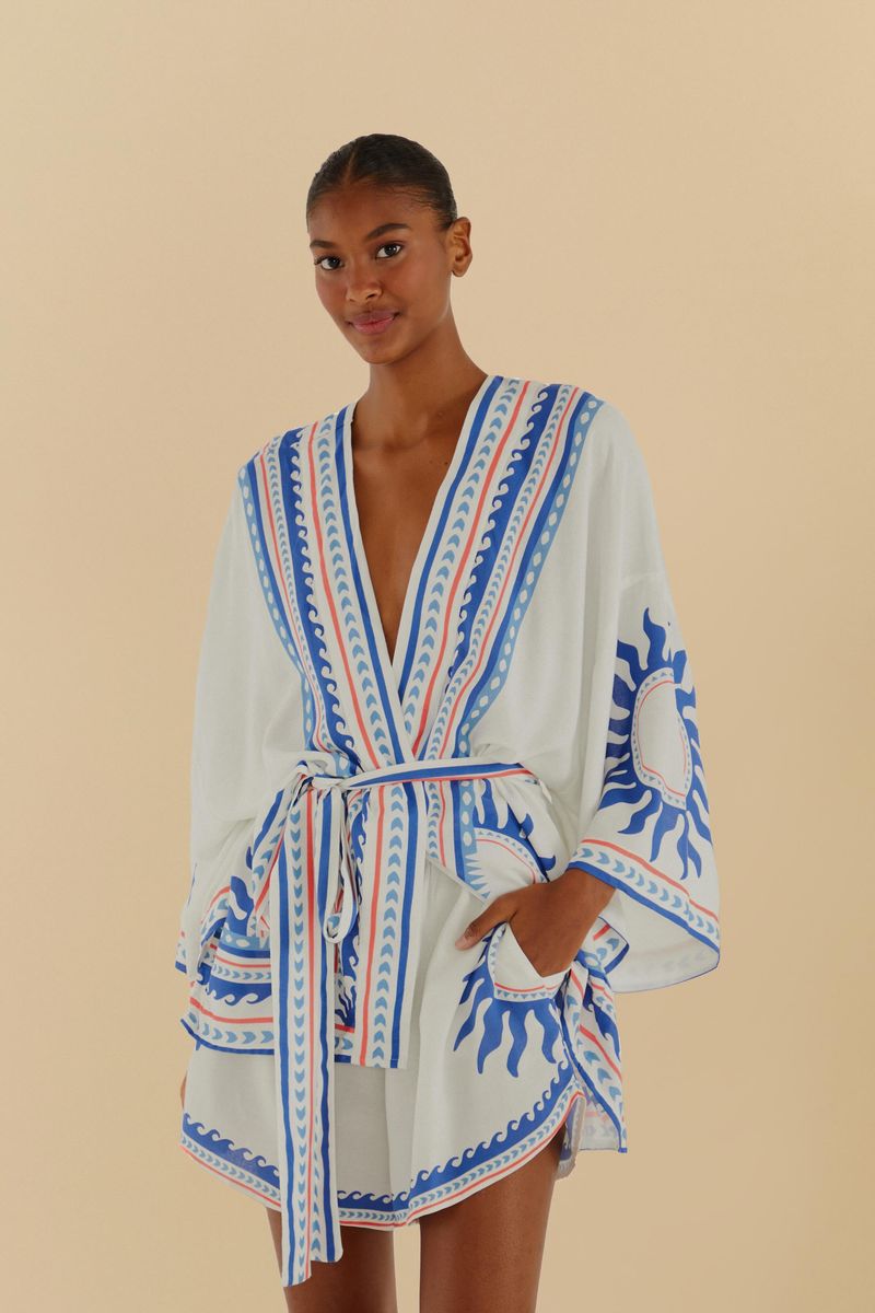Modelo usando un conjunto de kimono y short estampado con detalles abstractos en tonos azul y rojo.