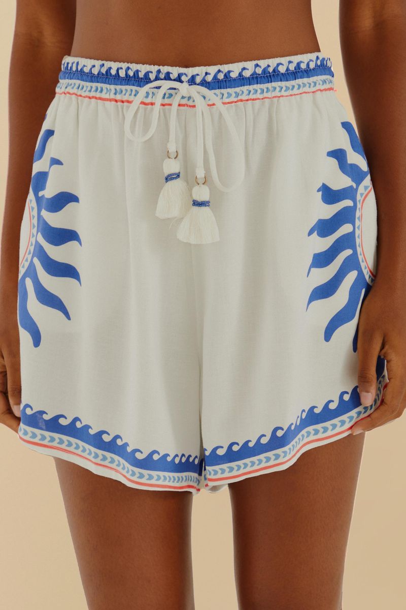Primer plano del short con estampado abstracto en azul y rojo, mostrando la cintura con lazada.