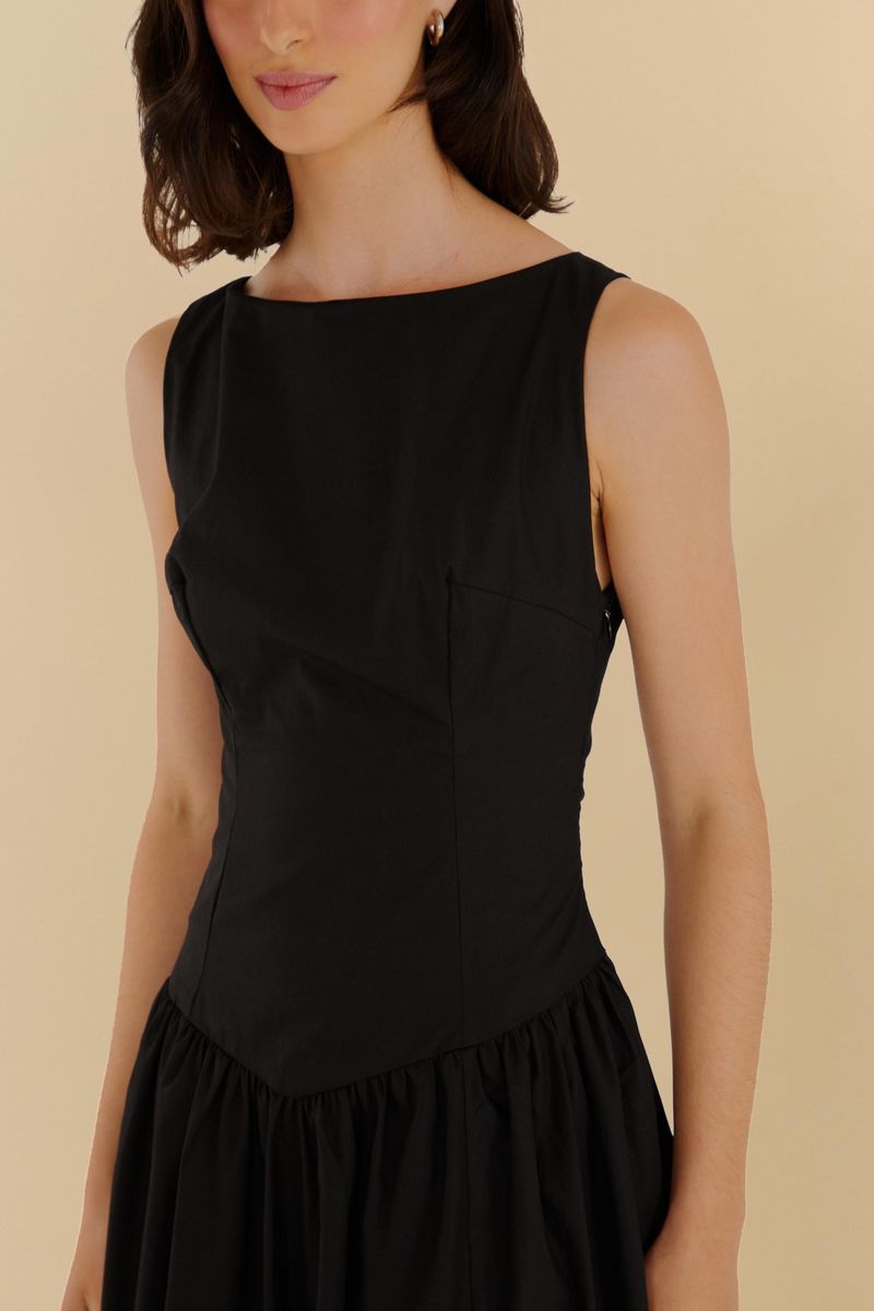 Primer plano del escote y las tiras anchas del vestido negro.