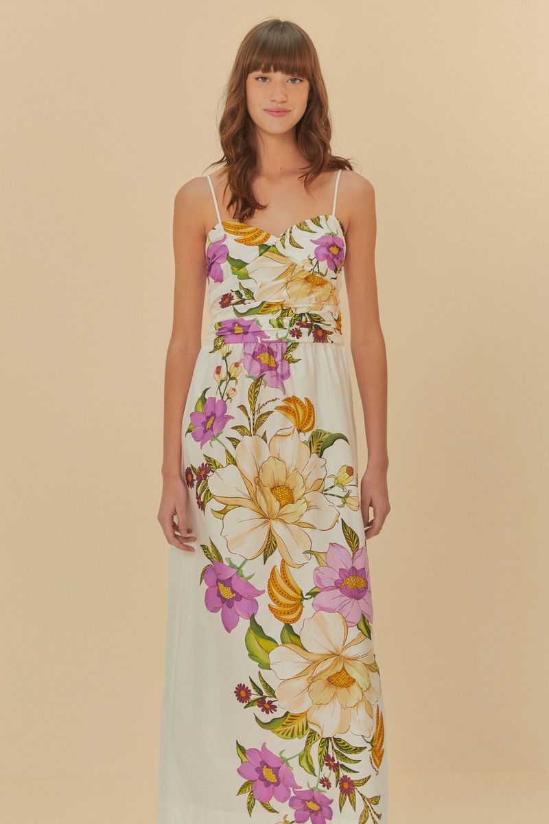 Vestido largo estampado con tirantes finos, fondo beige y flores coloridas, detalle del corpiño.