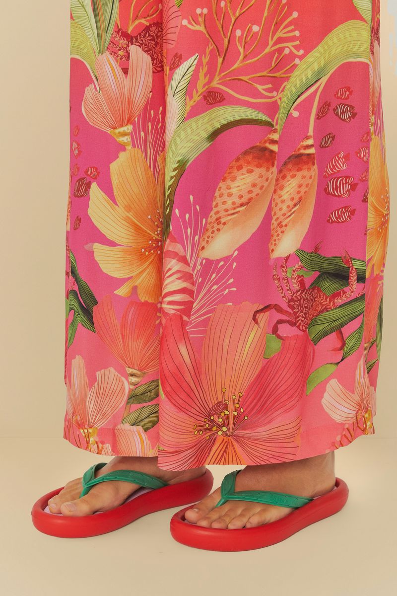 Detalle del chinelo rojo y verde en un look de verano.