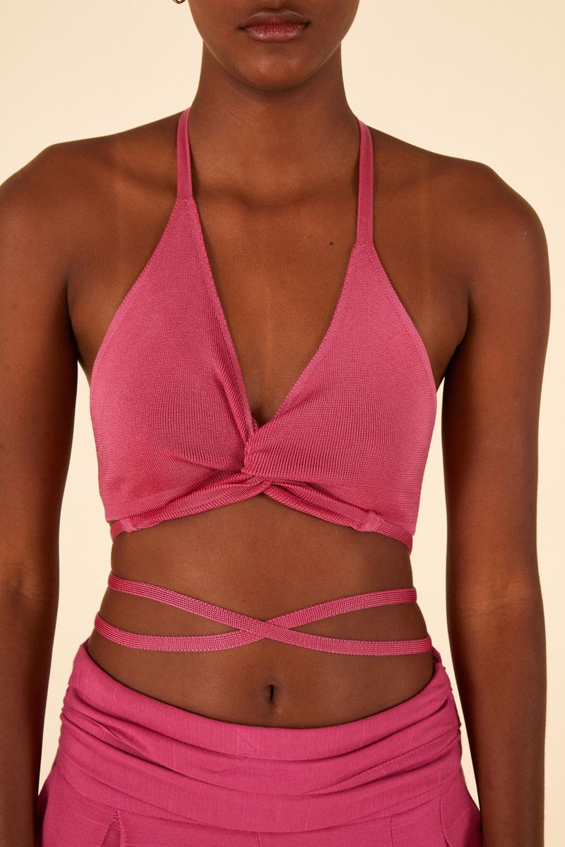 Imagen de un top de bikini tejido rosado con diseño de amarre en detalle frontal.