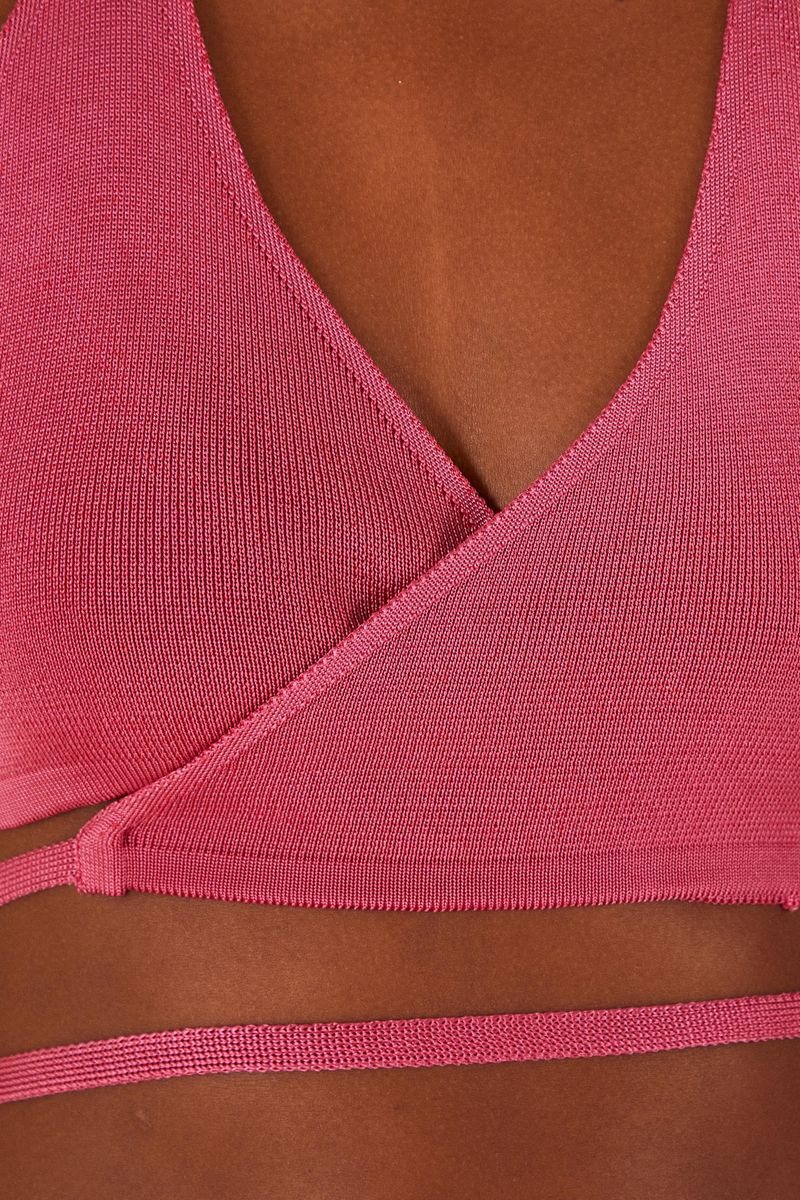 Imagen de un top de bikini tejido rosado con diseño de amarre en detalle lateral.