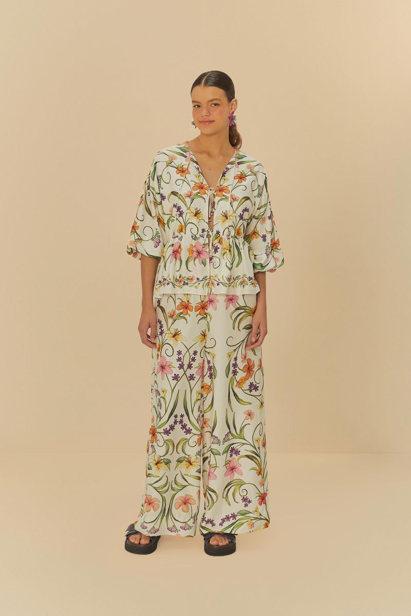 Imagen de un pantalón largo con estampado floral tropical, visto de frente.