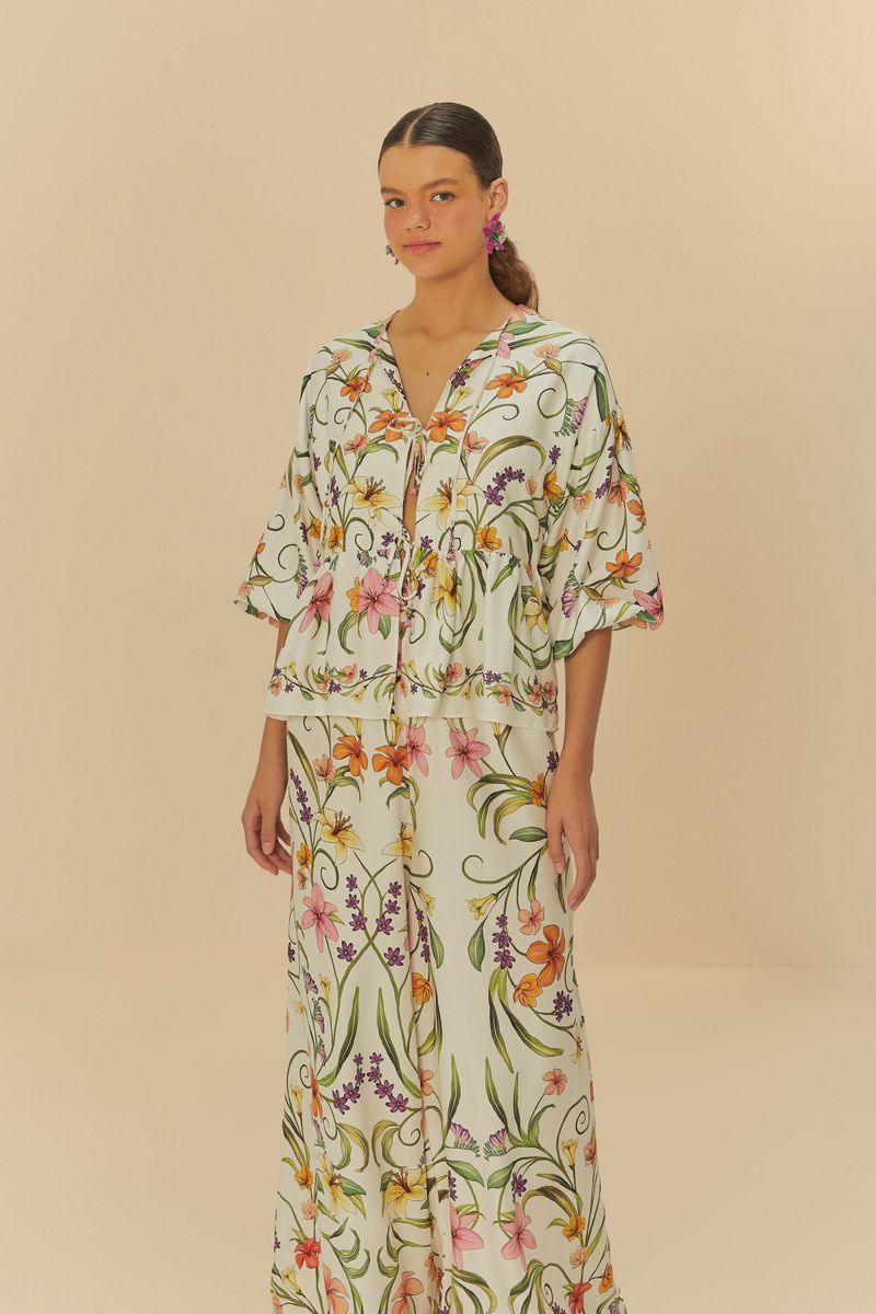 Imagen de un pantalón largo con estampado floral tropical, visto de lado.