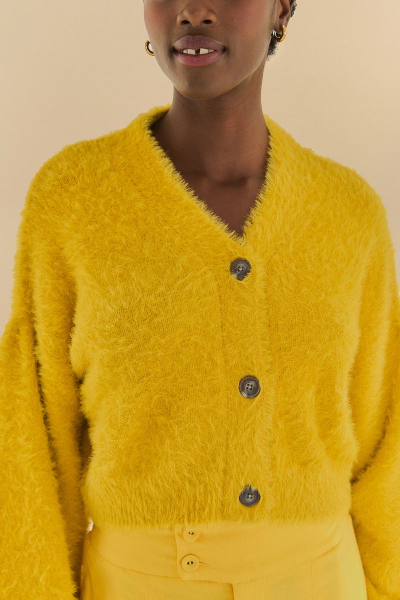 Detalle del cardigan corto peluche amarillo con botones.