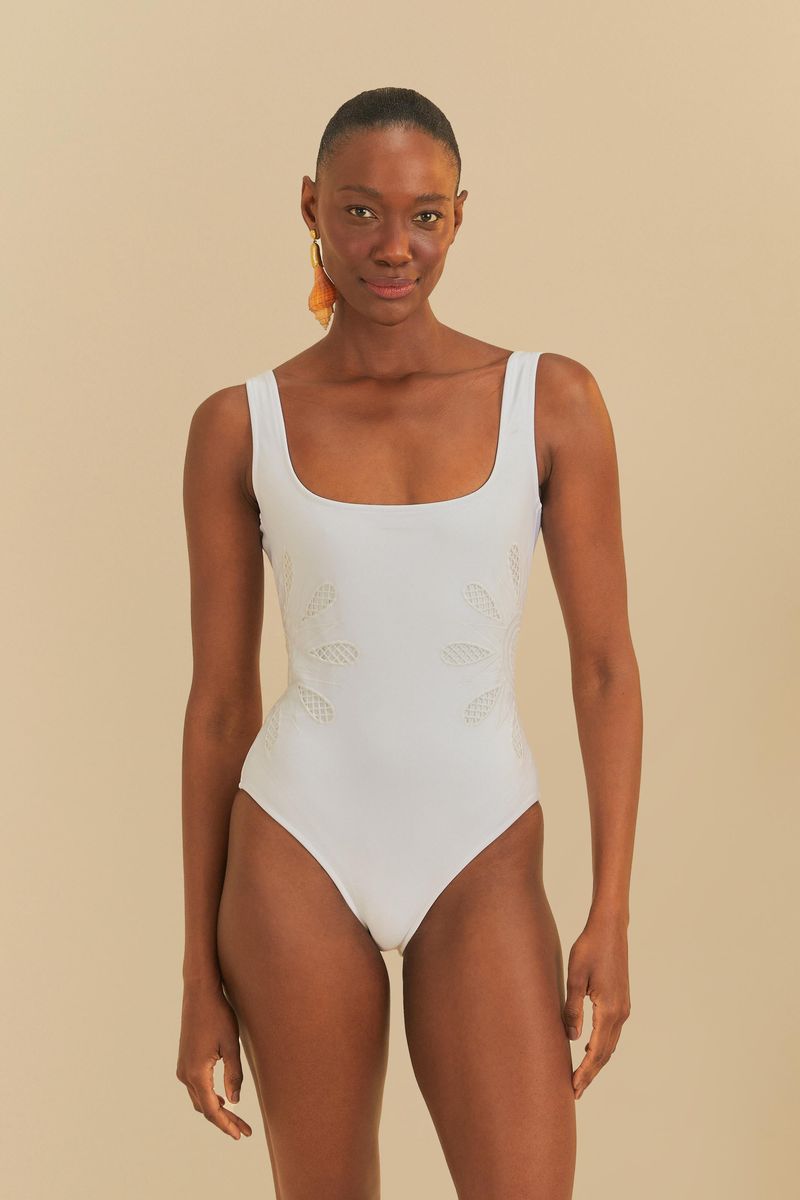 Vista frontal de un traje de baño blanco con detalles bordados artesanales, exhibido en un modelo.