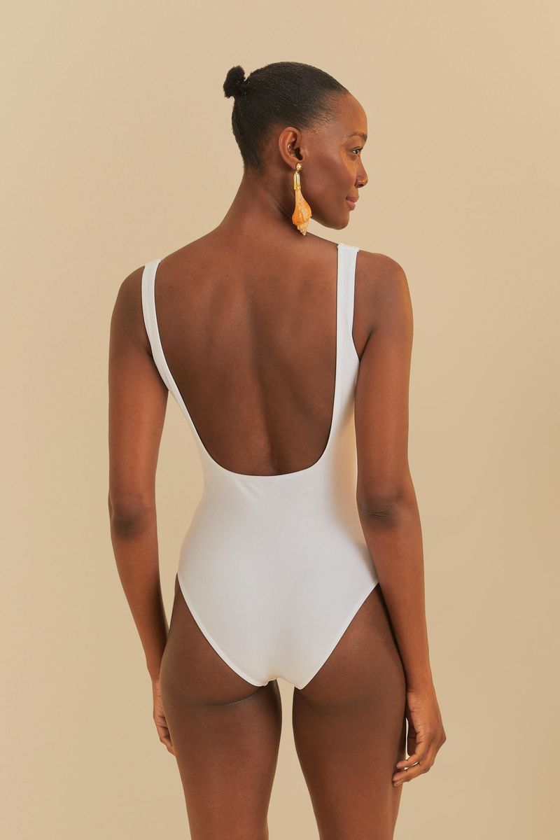 Vista trasera del traje de baño blanco con diseño minimalista y tirantes finos.