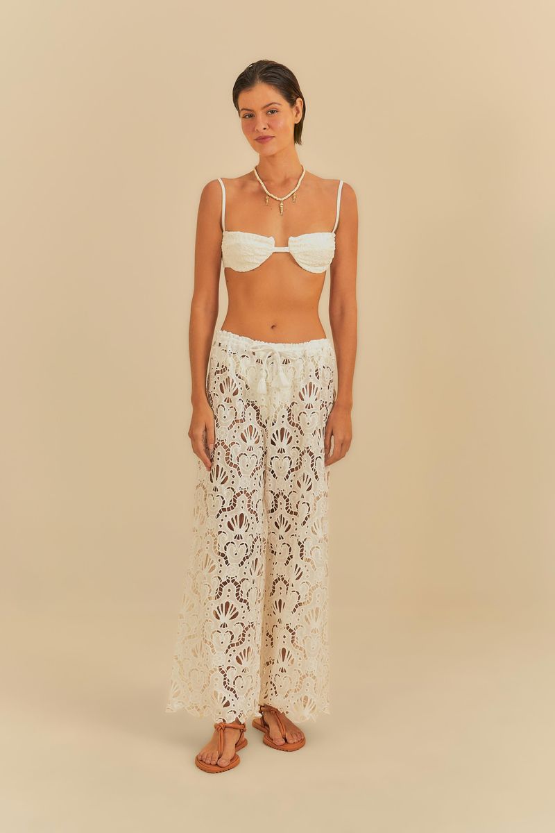 Bikini media taza con estampado de conchas combinado con pantalón largo de encaje, creando un look playero elegante.