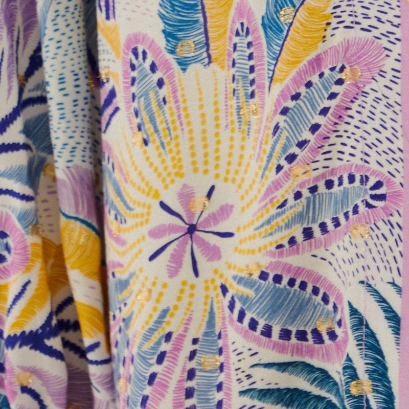 Detalle del estampado tropical con elementos florales y hojas.