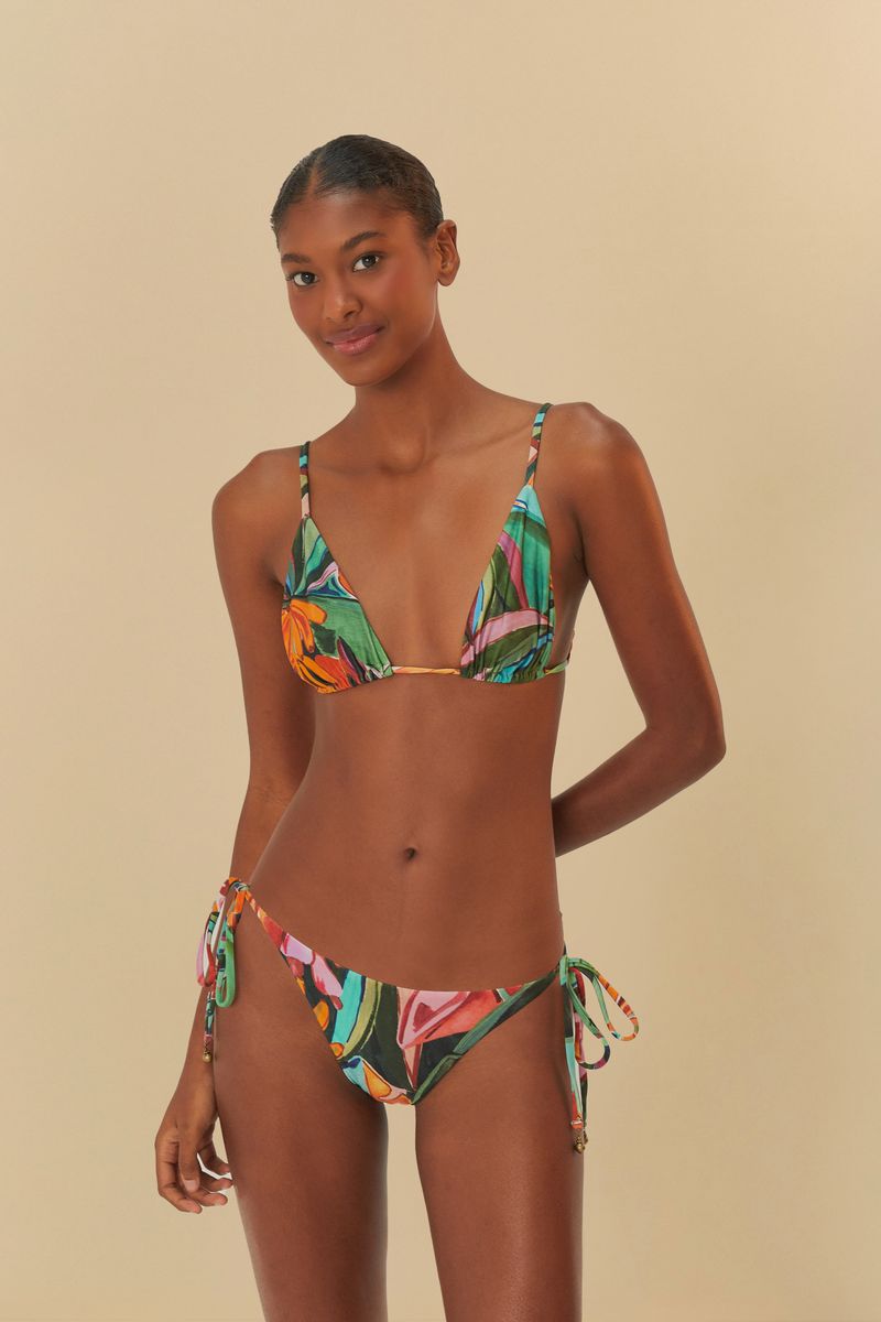 Vista lateral del bikini con estampado tropical, resaltando los detalles de lacito.