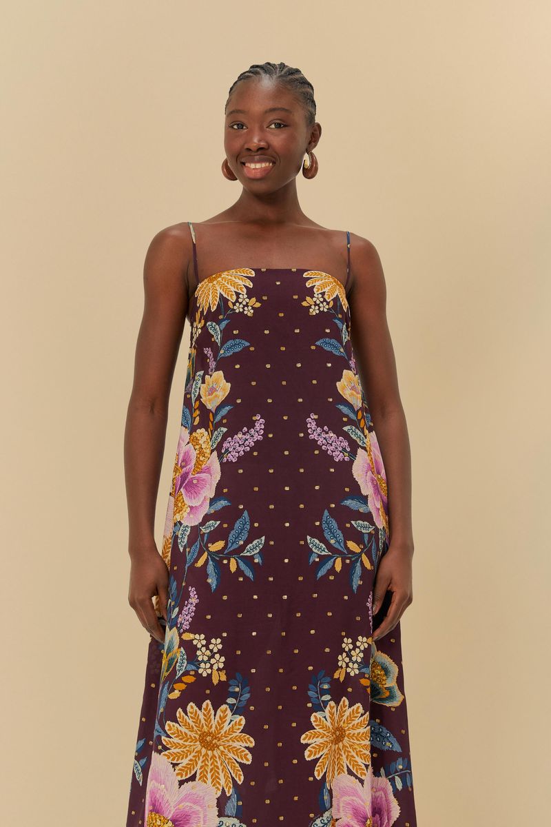Detalle del vestido mostrando el estampado floral con elementos botánicos y fondo púrpura.