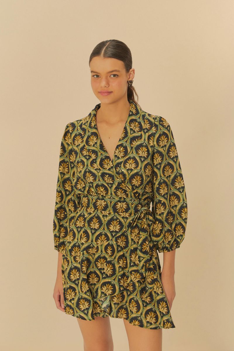 Modelo usando un vestido corto con estampado bohemio floral en tonos verdes y amarillos, con mangas largas y escote en V.