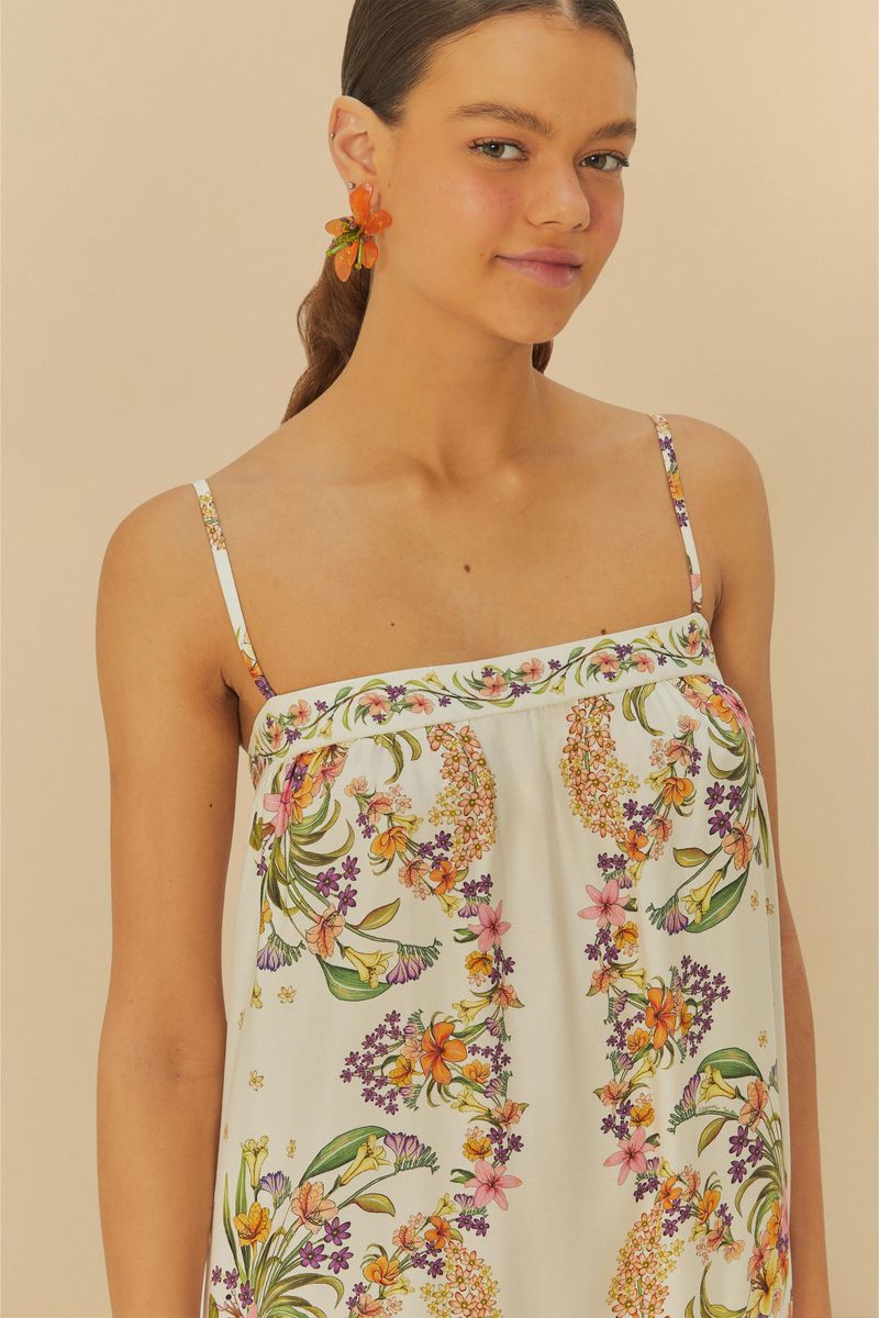 Vestido estampado con tirantes finos, diseño floral y borde en capas, visto desde atrás.