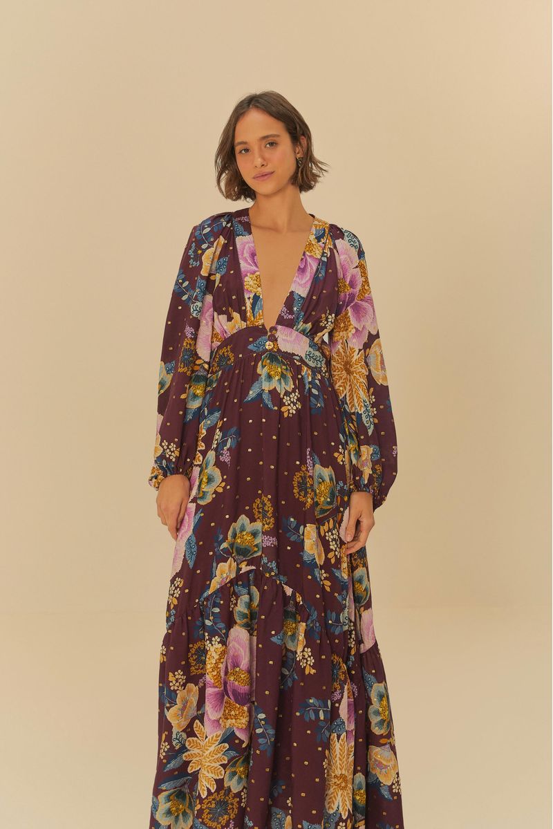 Vista frontal del vestido largo estampado con detalles florales sobre fondo púrpura.