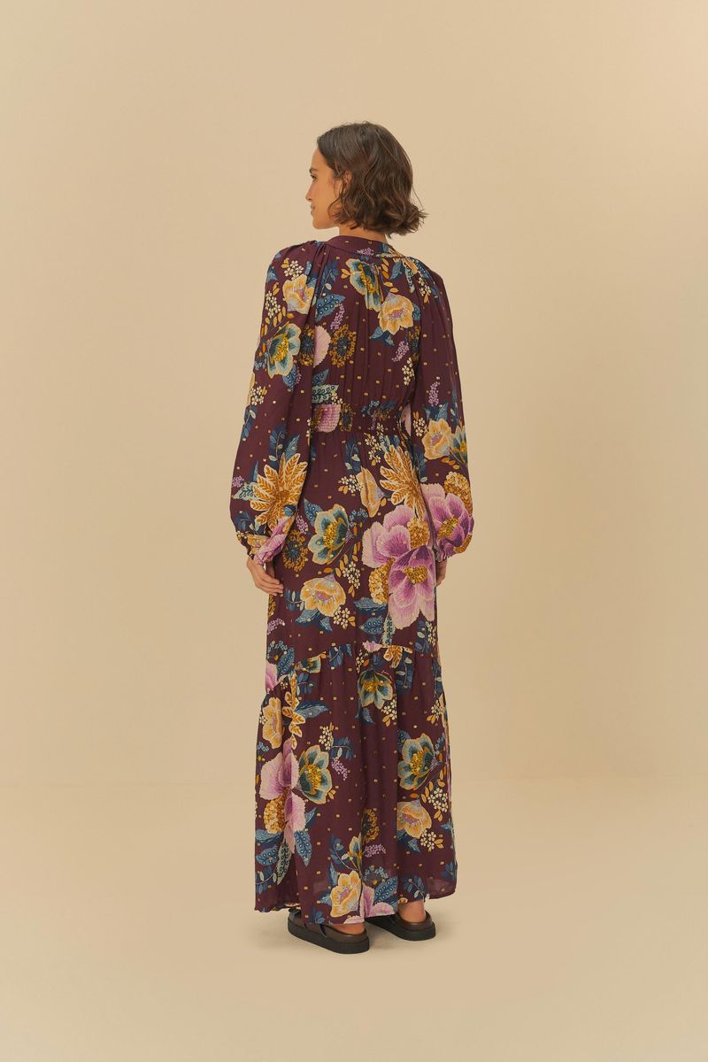 Vista trasera del vestido largo estampado con fondo púrpura y flores grandes.