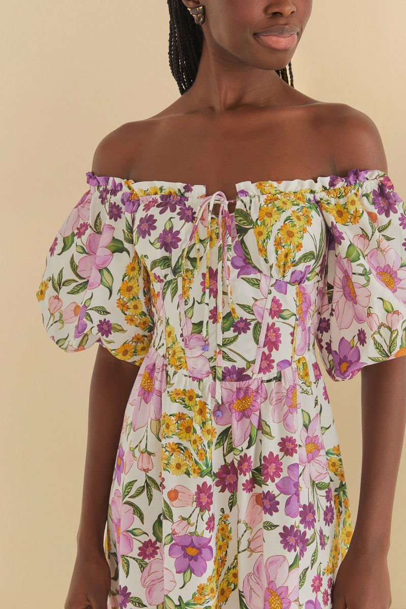 Detalle del vestido mostrando el diseño floral vibrante con elementos botánicos y frutas.