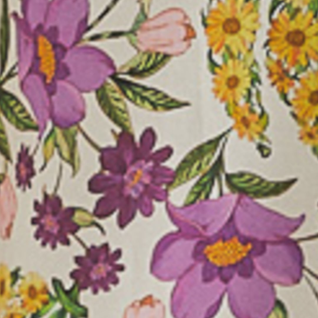 Detalle de la estampado del tejido con flores y frutas en colores vibrantes.