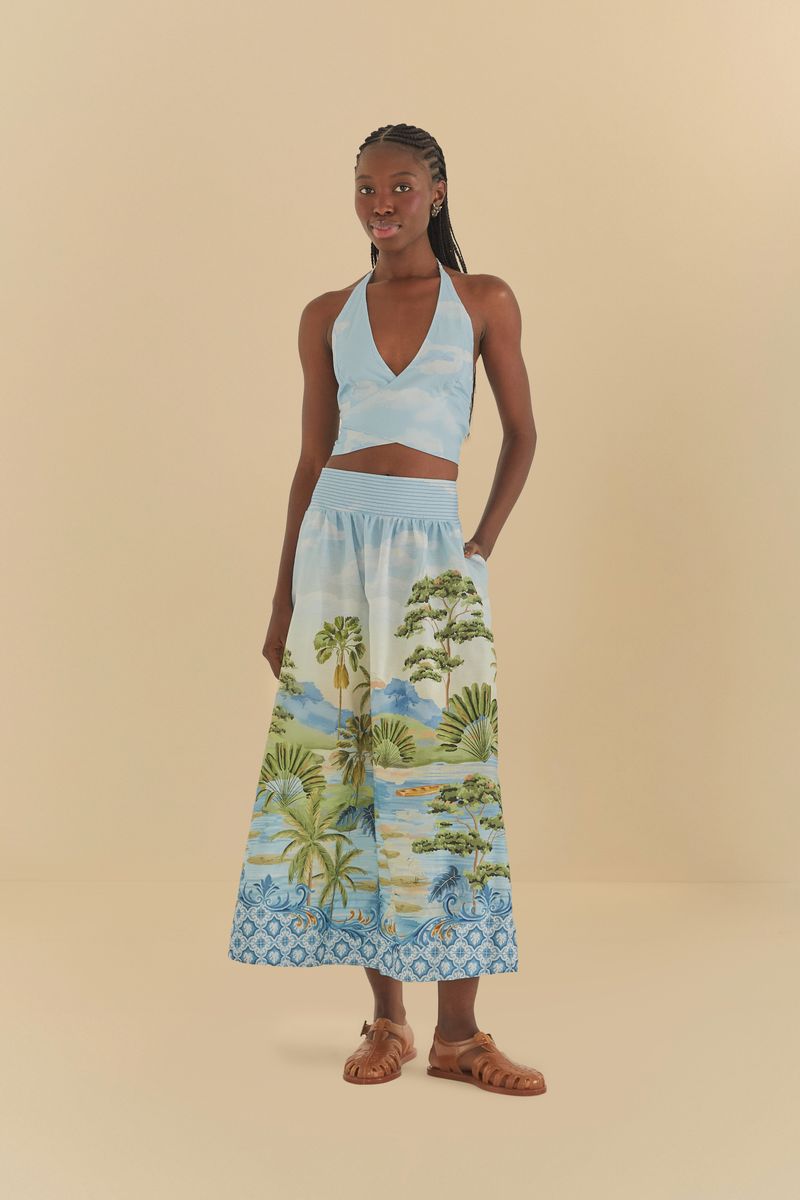Modelo usando falda con estampado paisajístico en tonos de verde y azul, vista frontal.