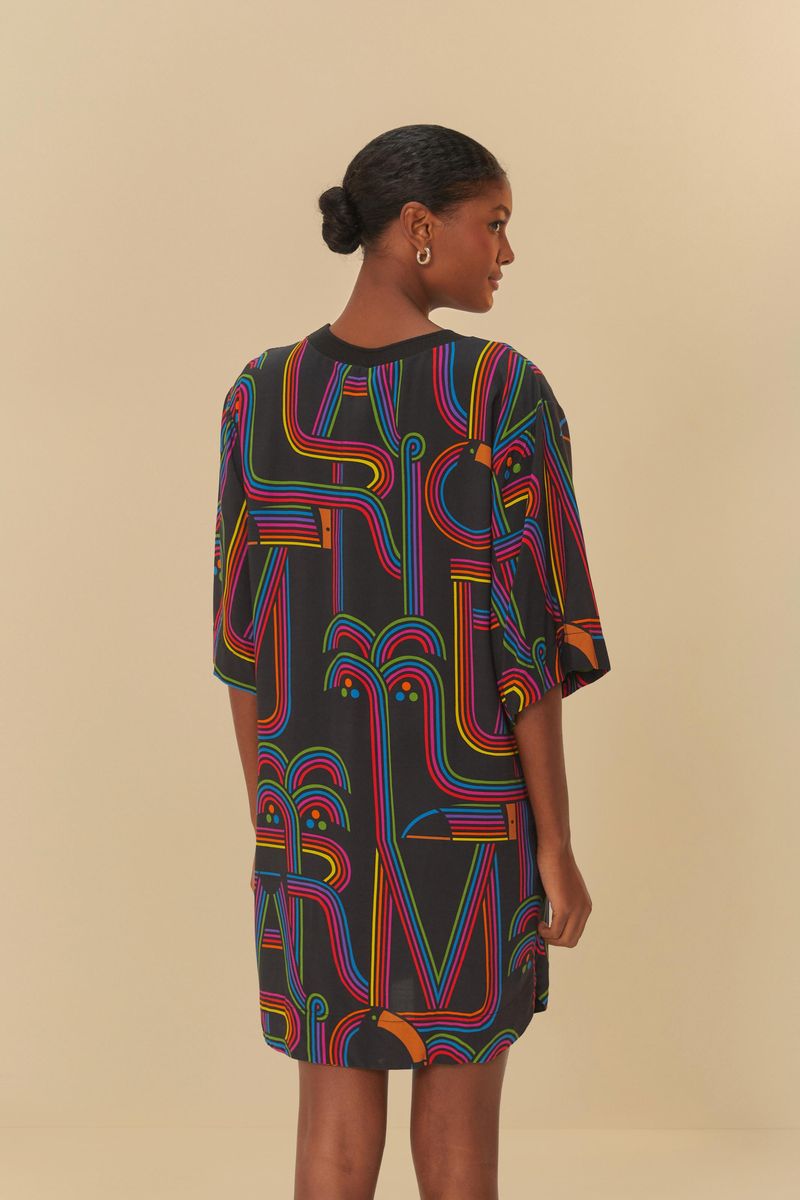 Vista trasera del vestido estilo camiseta con estampado geométrico colorido sobre fondo negro.