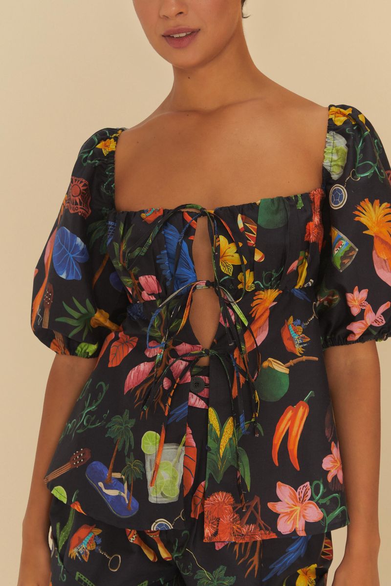 Detalle del escote y cierre con amarre de la blusa estampada.