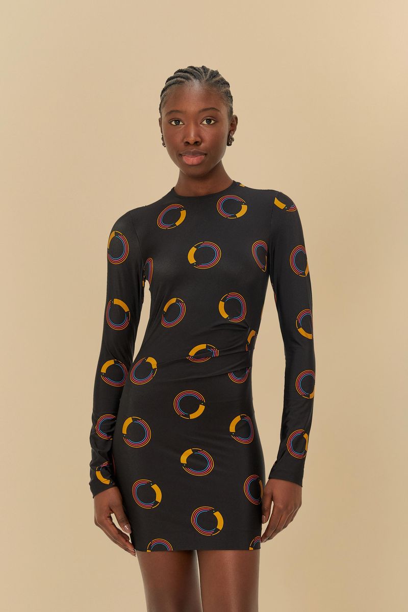 Vestido corto con estampado de círculos coloridos, manga larga y cuello alto, visto de frente.