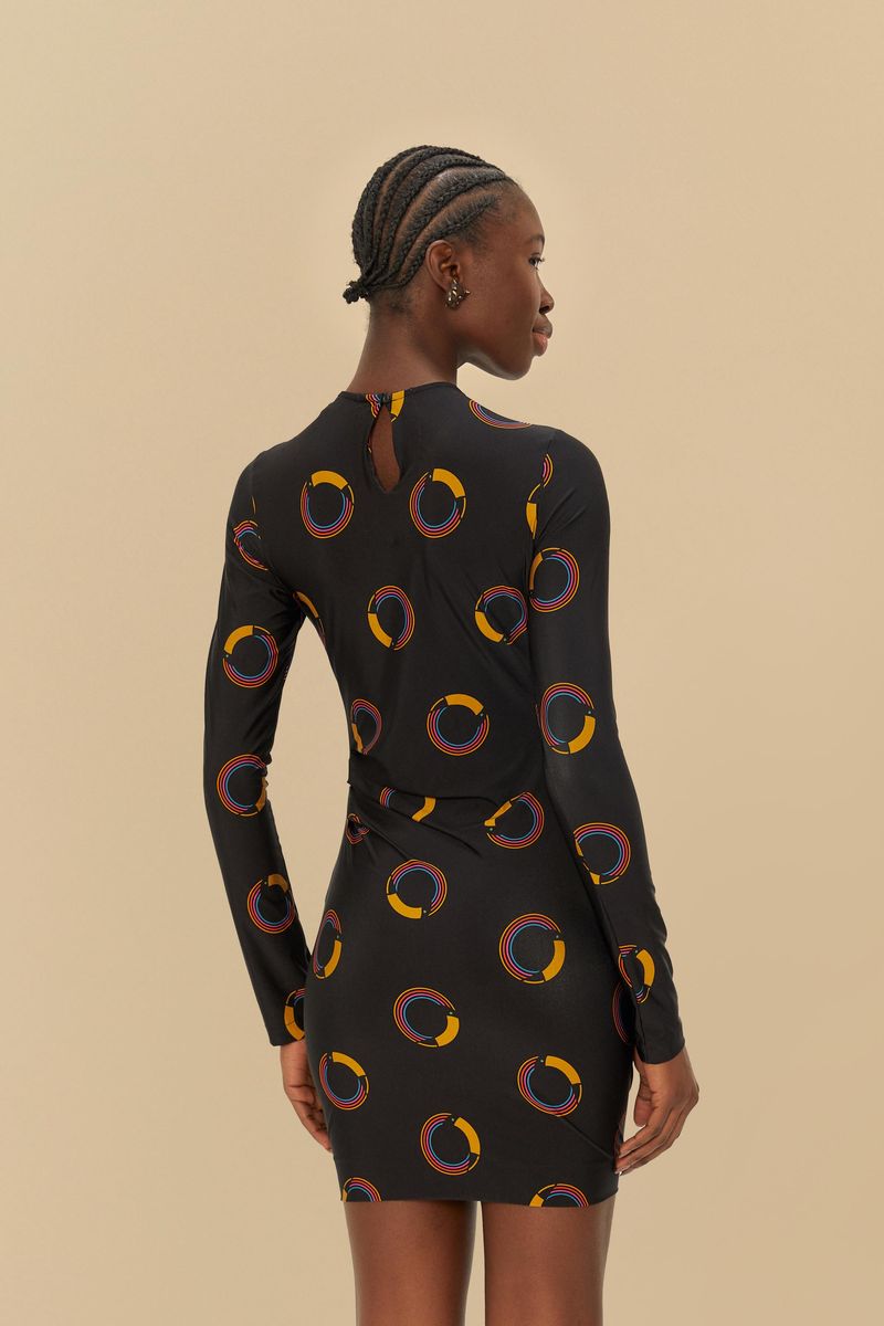 Vista trasera del vestido corto con estampado de círculos coloridos, destacando el cierre en la parte superior.