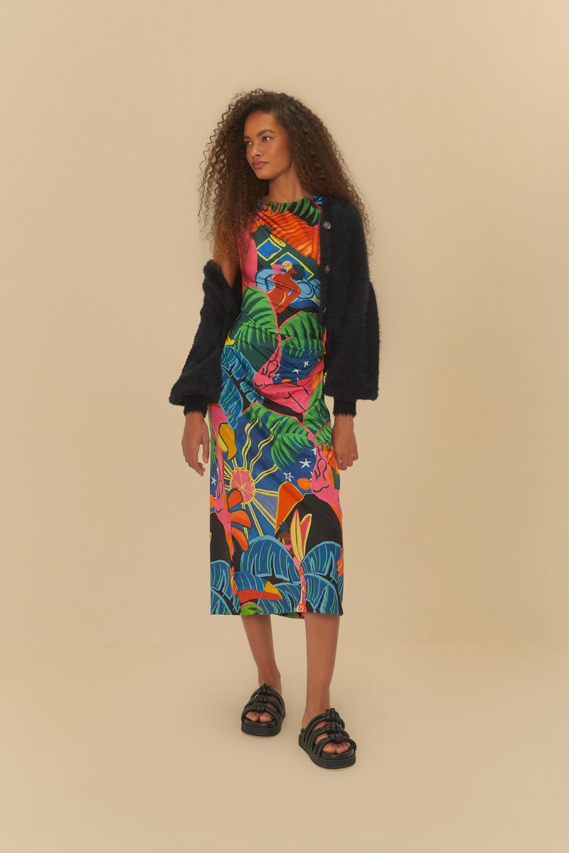 Vestido con diseño tropical, combinado con abrigo negro y sandalias, mostrando un estilo casual.