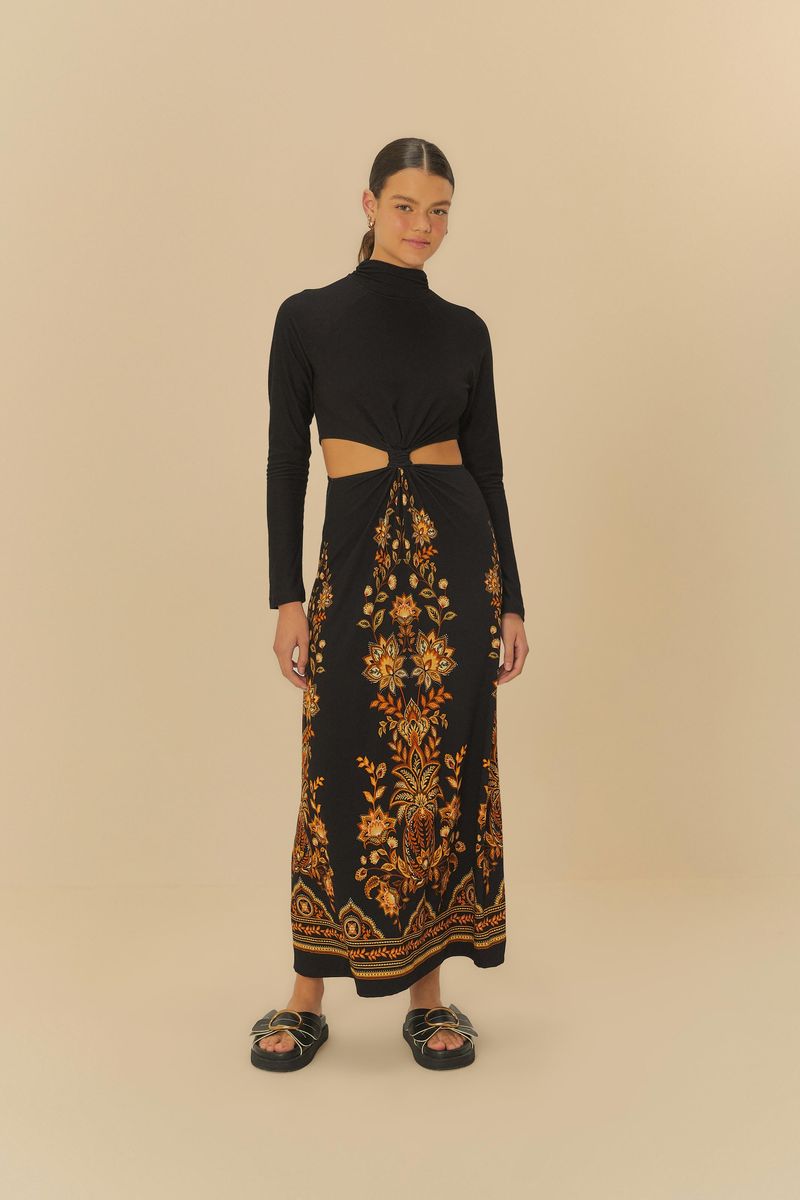 Modelo utilizando vestido corto con estampado floral y detalles de piña, con mangas largas y cuello alto.