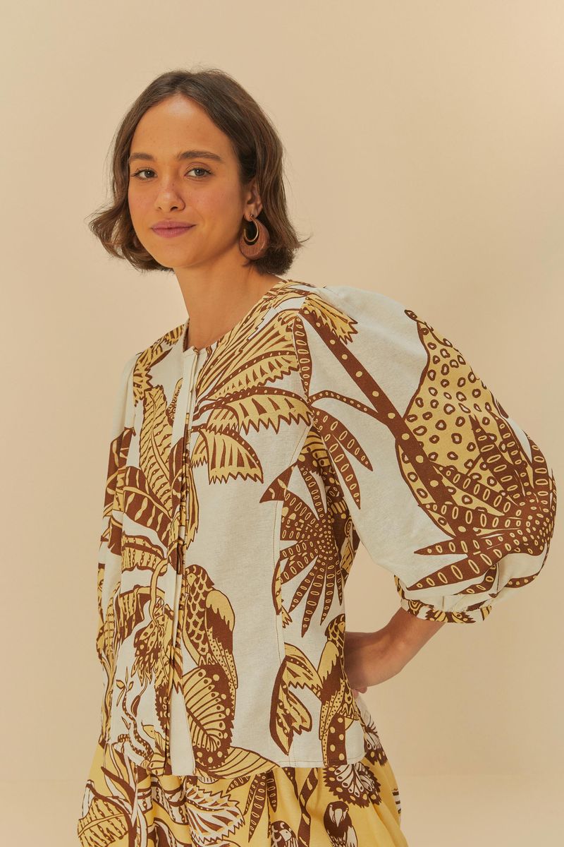 Imagen de un top estampado tropical con mangas voluminosas visto de frente.