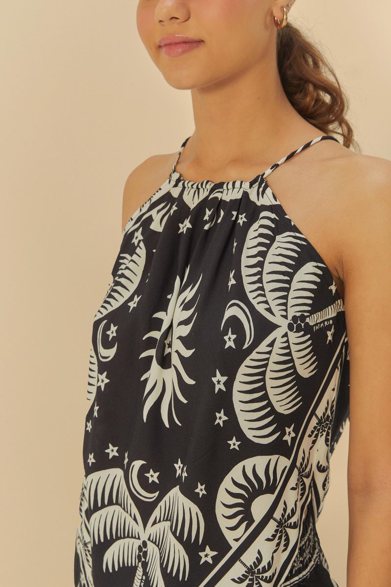 Imagen de una camiseta sin mangas estampada con palmeras y elementos astrológicos, detalle del escote.
