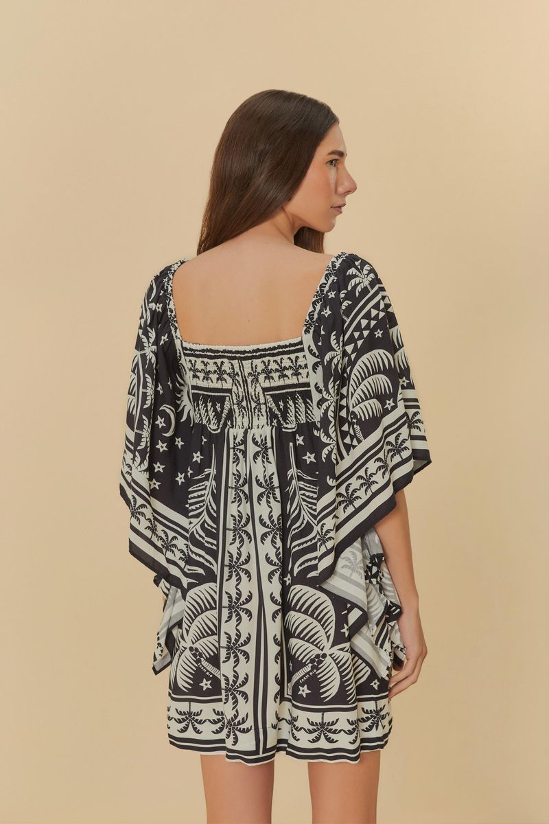 Vista trasera del vestido corto estampado con mangas estilo kimono y estampado de palmeras.