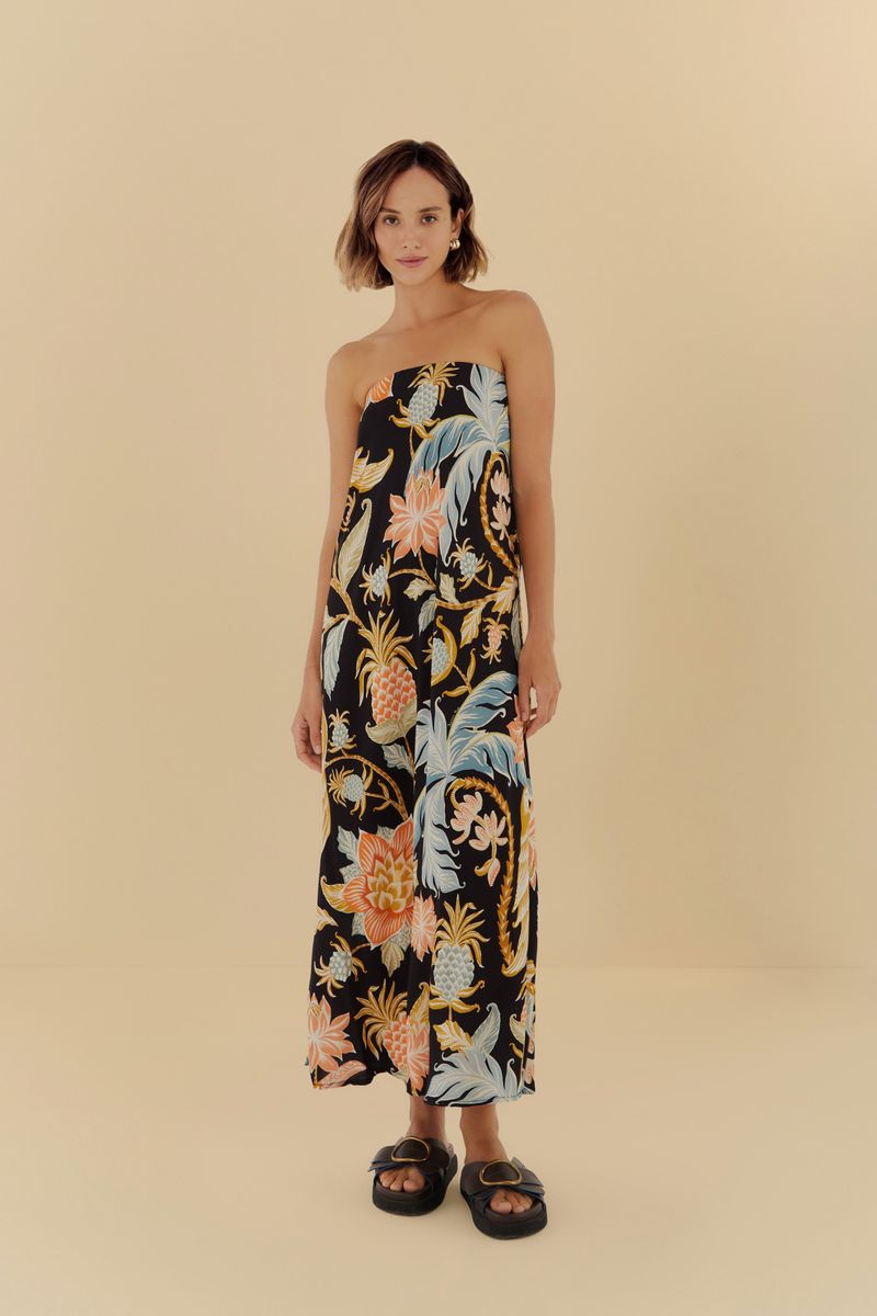 Imagen de un vestido largo estampado con fondo negro y detalles florales y botánicos, visto de frente.