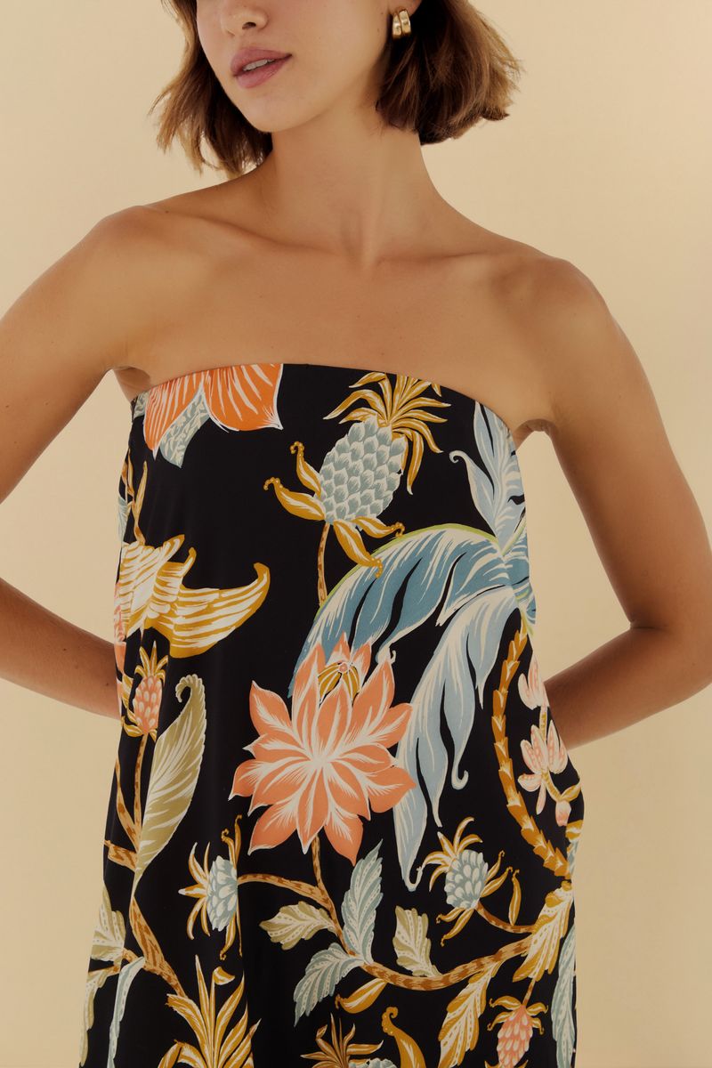 Imagen de un vestido largo estampado con fondo negro y detalles florales y botánicos, mostrando el detalle del corsé.