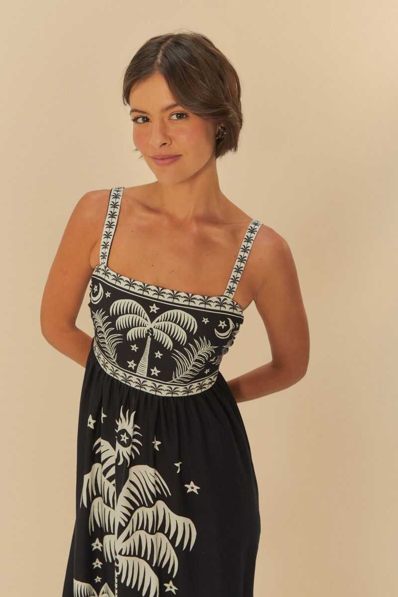 Vestido midi estampado con palmeras y elementos tropicales, visto de perfil.