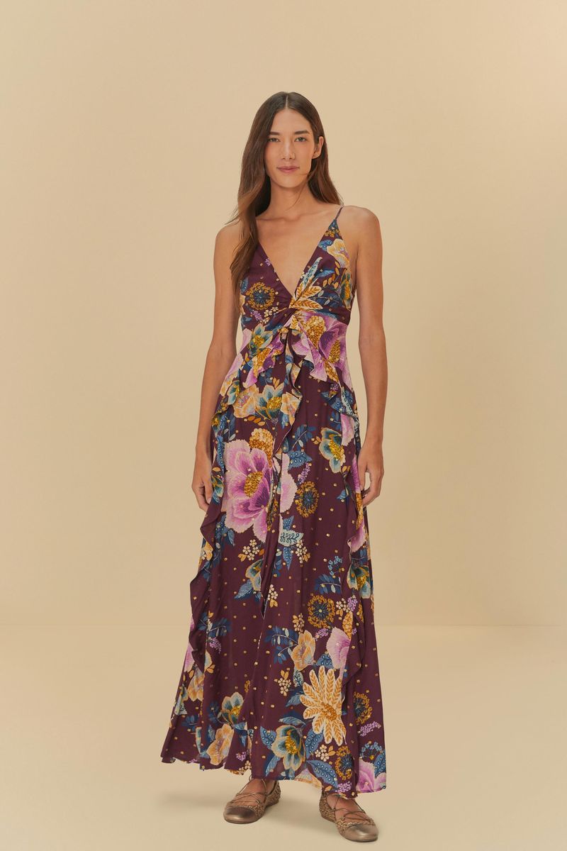 Vestido largo con estampado floral en fondo morado, con volantes y escote en V.