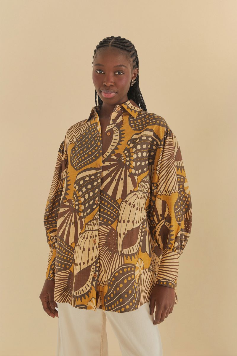 Camisa estampada con motivos botánicos y geométricos en colores tierra, vista frontal.