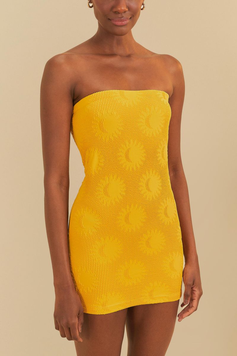 Vestido amarillo con estampado de sol, modelo de lado.