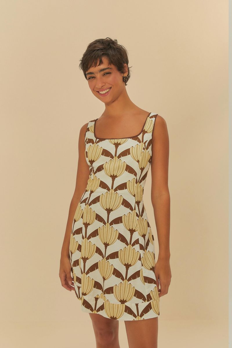 Vestido corto con estampado de bananas sobre fondo claro, visto de frente.