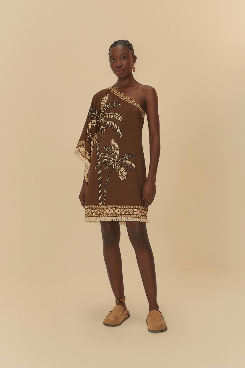 Vestido corto con estampado tropical sobre fondo marrón, modelo de un solo hombro, mostrado en pose frontal.