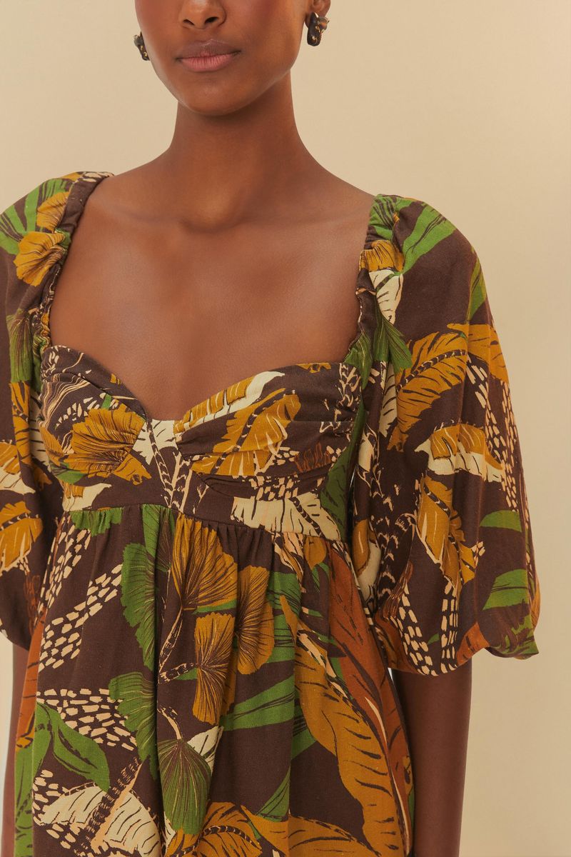 Detalle del escote profundo del vestido corto con estampado tropical, destacando el ajuste y el patrón.