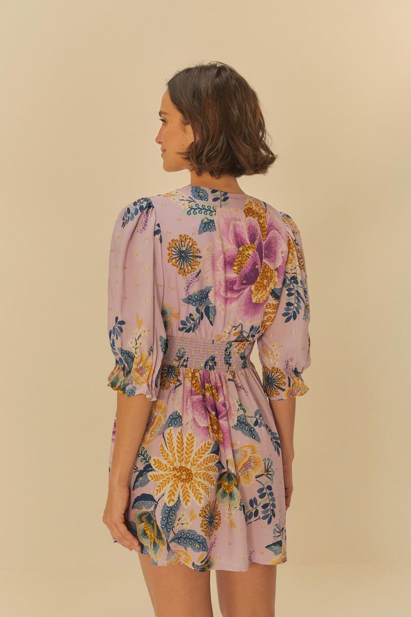 Vista trasera del vestido corto con estampado floral, destacando el diseño de la espalda y la silueta.