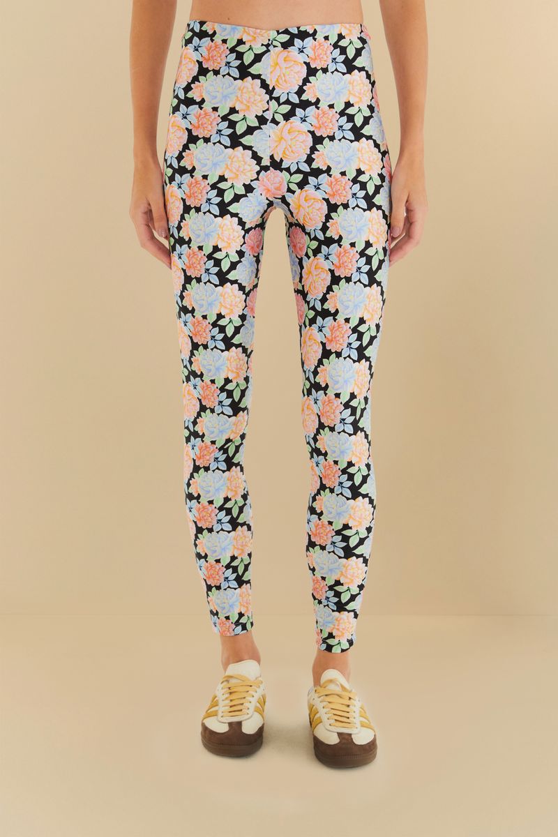 Imagen de unas leggings con estampado floral sobre fondo negro, vista trasera.